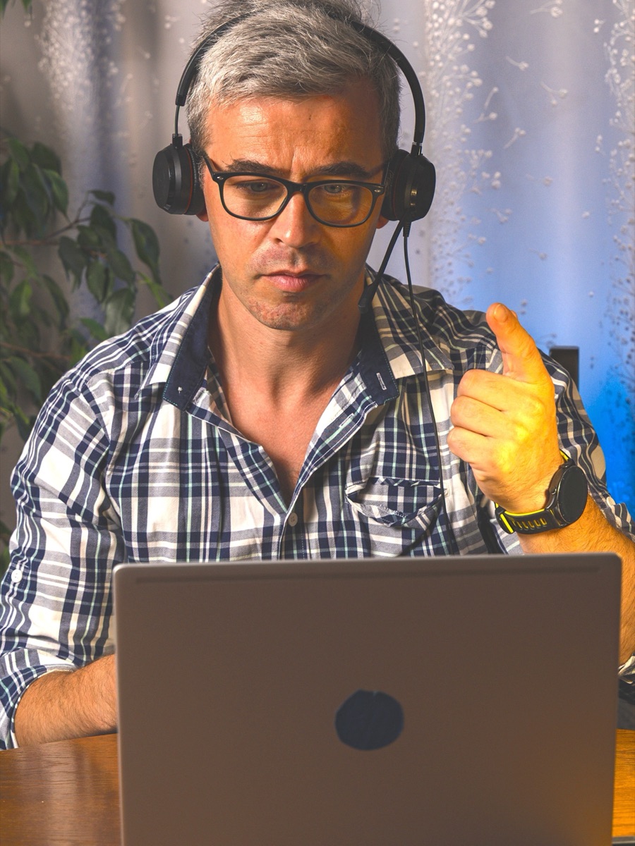 A consultant on a video call at his desk in the evening